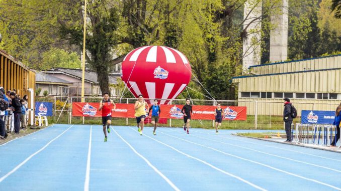 Atletas compitiendo en la pista atlética durante el Interescolar Mixto de Atletismo Soprole en Puerto Montt