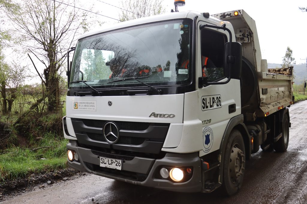 Transporte escolar atascado en camino rural deteriorado en Villarrica